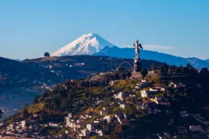 View of Quito with the iconic statue and snow-capped mountain, near Casa Gangotena Boutique Hotel.