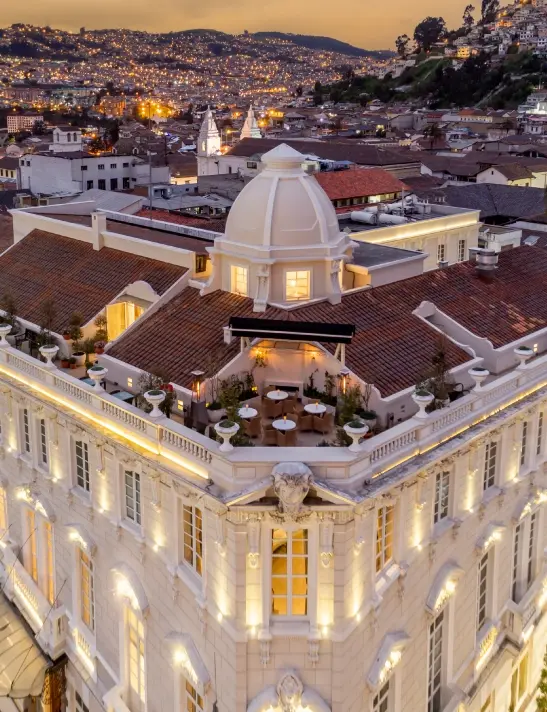 Vista elevada del Hotel Boutique Casa Gangotena en Quito al atardecer con las luces de la ciudad.