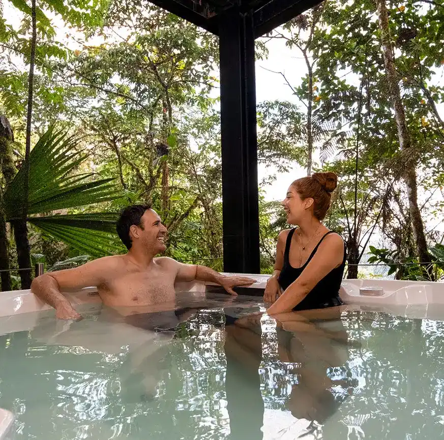 Couple enjoying a serene moment in a jacuzzi amidst the forest, part of the Casa Gangotena Boutique Hotel experience.
