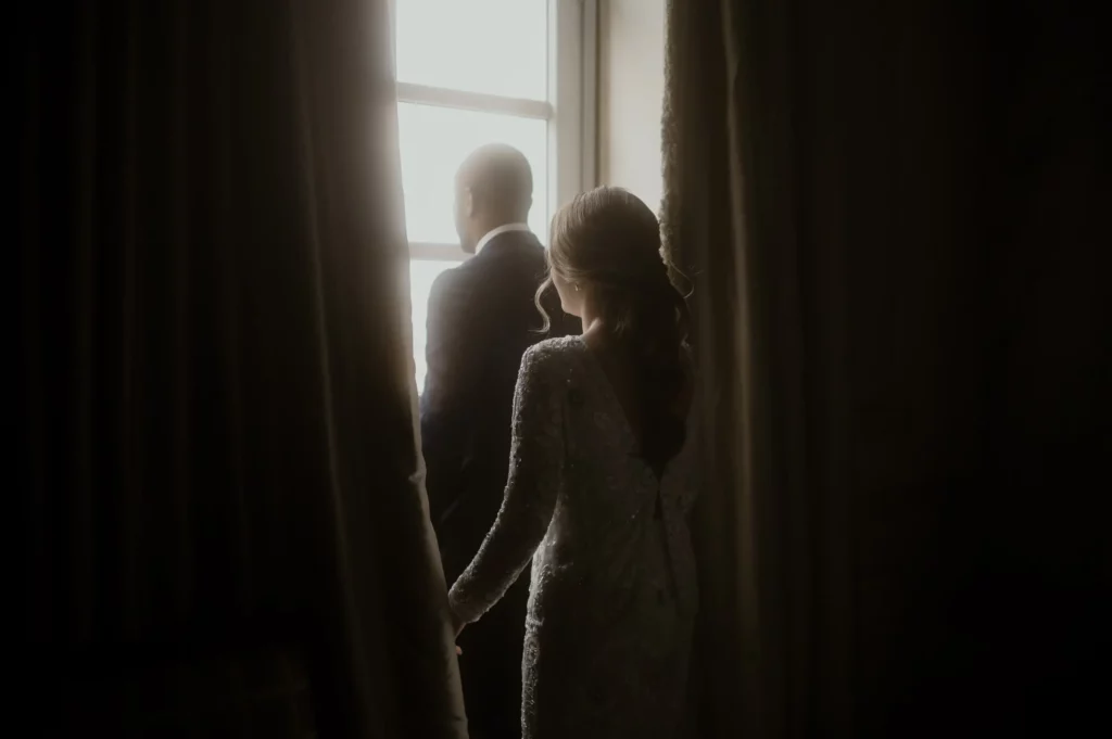 Couple holding hands by a window during wedding preparation at Casa Gangotena historic hotel Quito Couple holding hands by a window during wedding preparation at Casa Gangotena historic hotel Quito